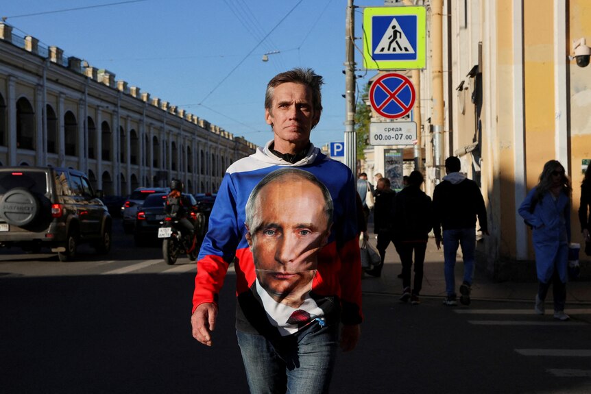 A man wearing Putin shirt crossing a street in Saint Petersburg last week.