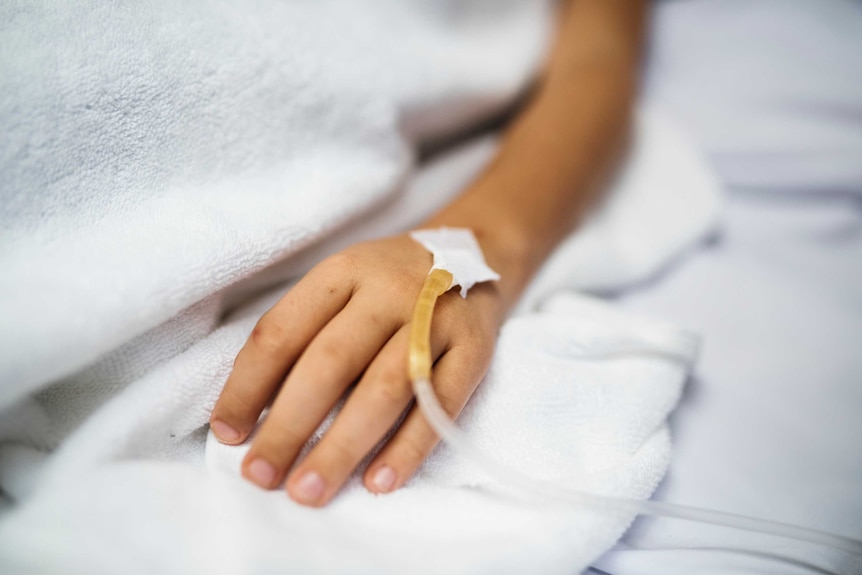 A hand with a drip tube inserted in it to depict the scary nature of being a patient in an intensive care unit (ICU).