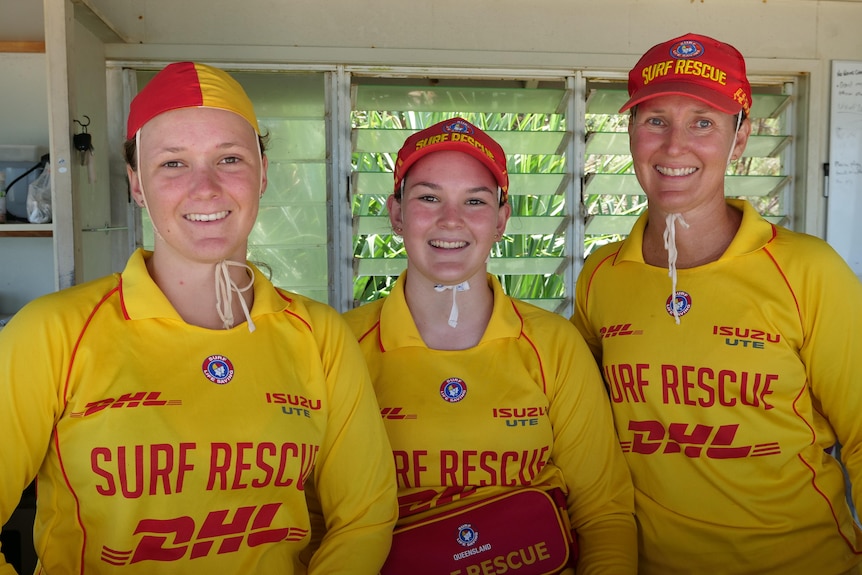 two sisters and their mum dressed in the surf lifesaving uniforms