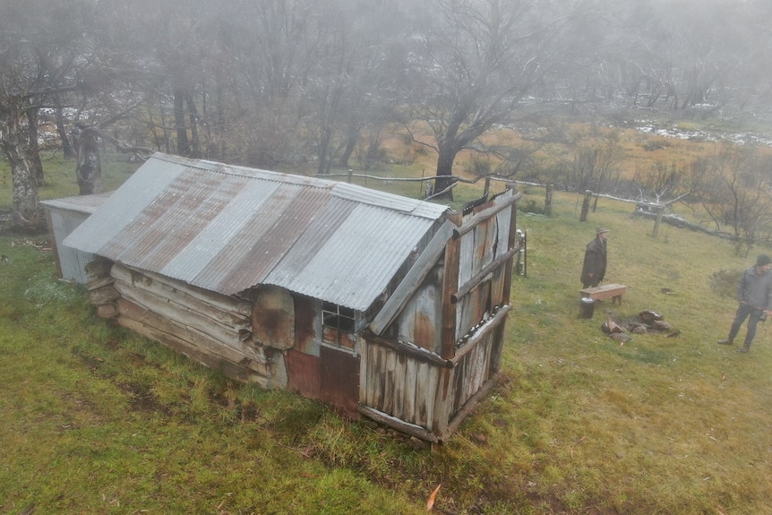 A hut shrouded in mist in the middle of a green plain in Victoria's High Country.