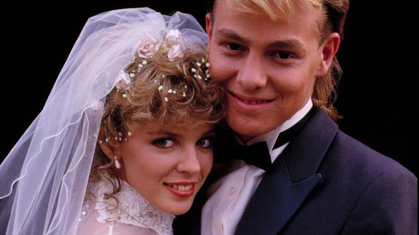 A young Kylie Minogue is dressed as a bride and actor Jason Donovan as a groom