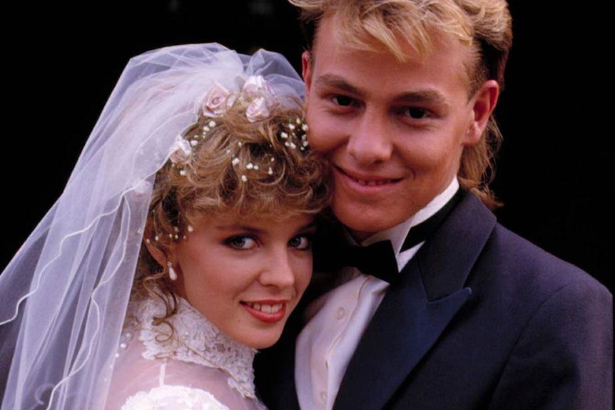 A young Kylie Minogue is dressed as a bride and actor Jason Donovan as a groom