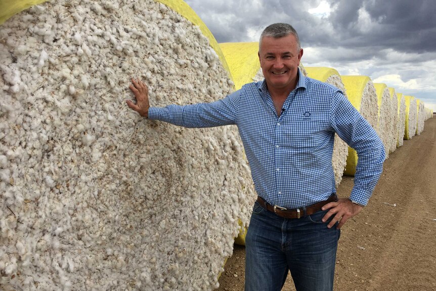 Cotton Australia CEO Adam Kay leans against a bale of cotton.
