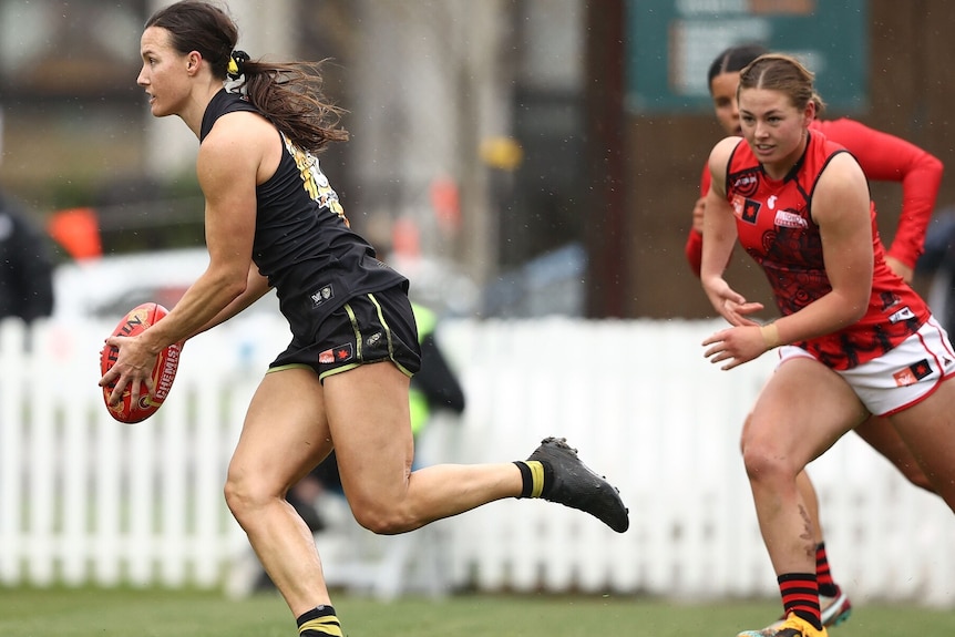 two AFLW players during a match