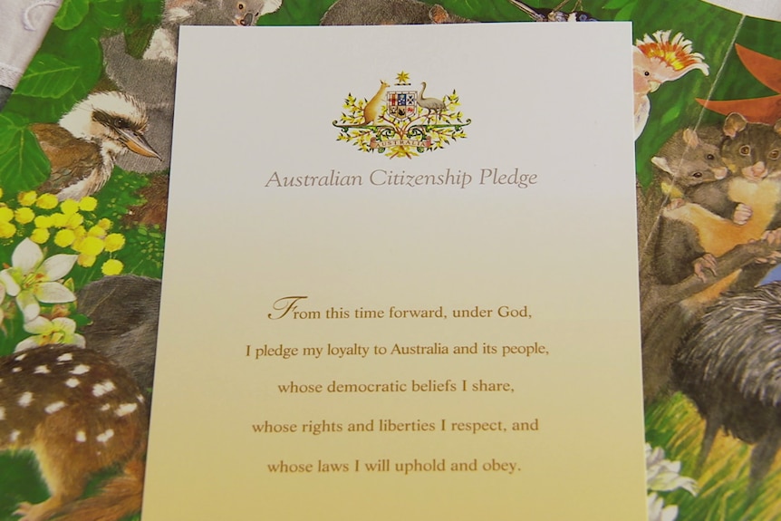 A certificate of the Australian Citizenship Pledge lays on a table cloth.