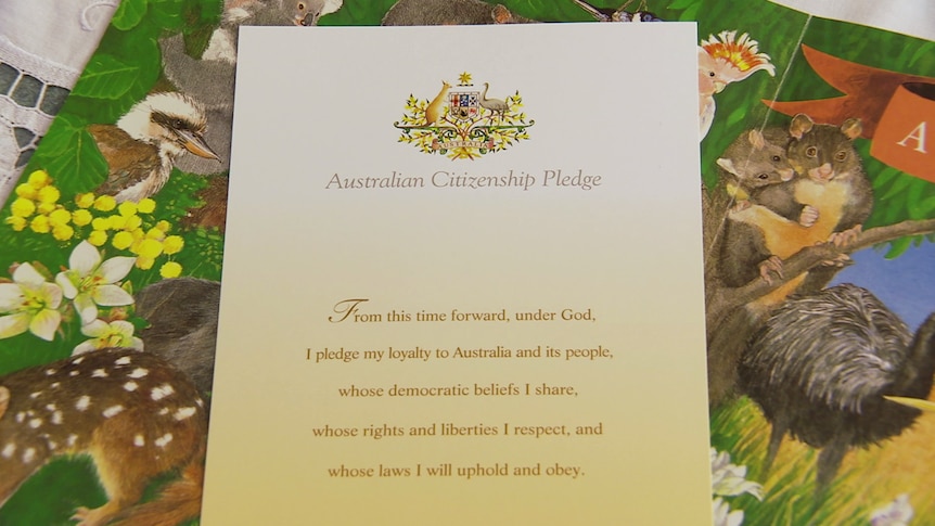 A certificate of the Australian Citizenship Pledge lays on a table cloth.
