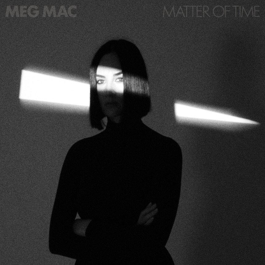 The art for Meg Mac's album Matter of Time showing her in shadow with a streak of light across her eyes, in black and white
