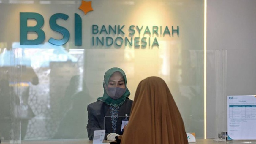 Two women doing a transactions in the syariah bank in Indonesia.