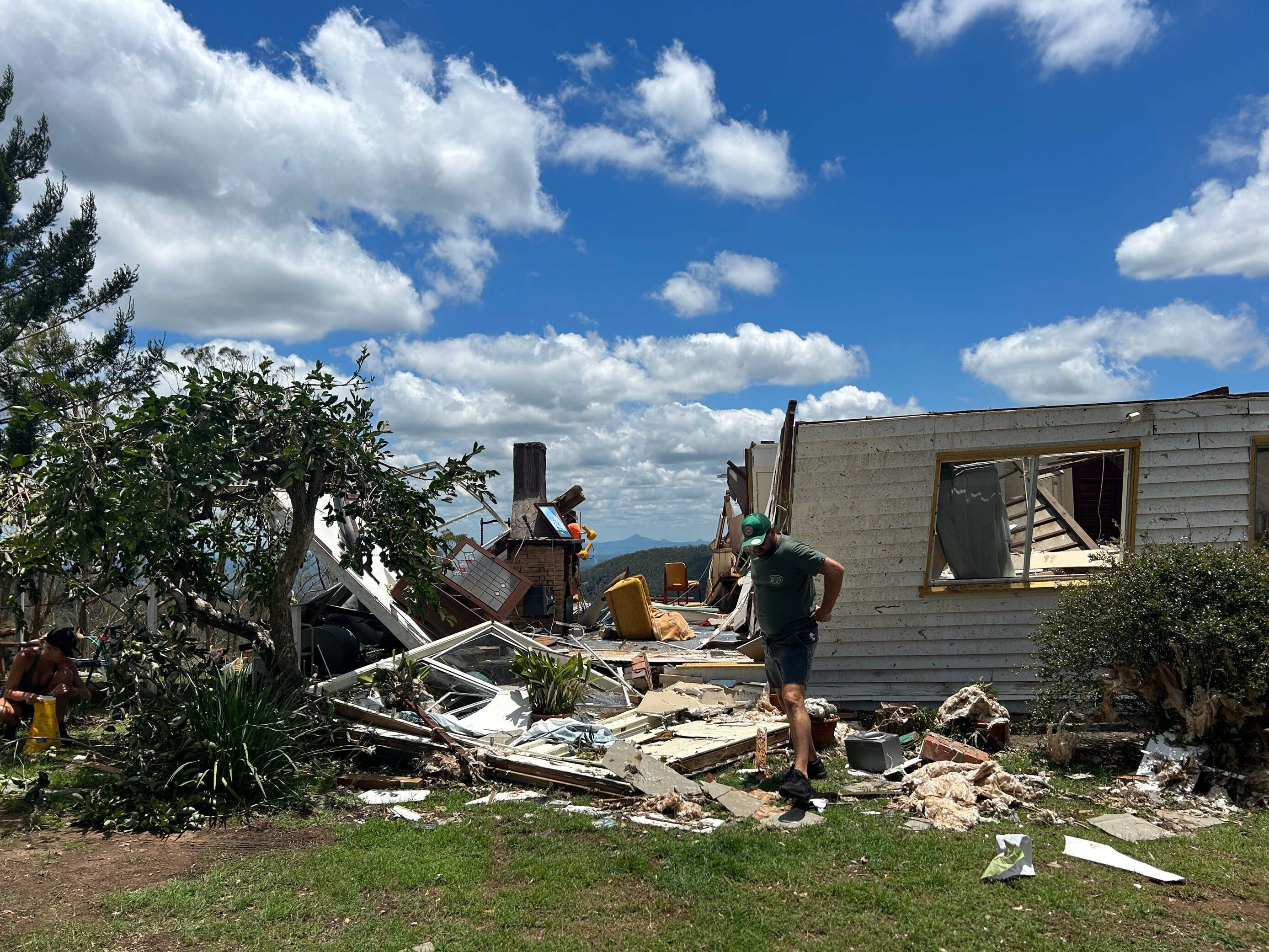 A home stands destroyed on a hill top. 