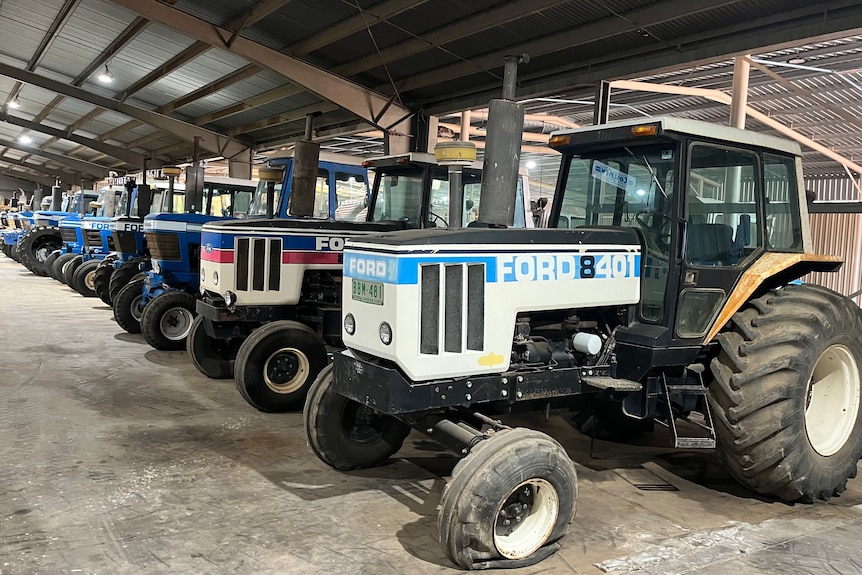A series of Ford tractors lines up.
