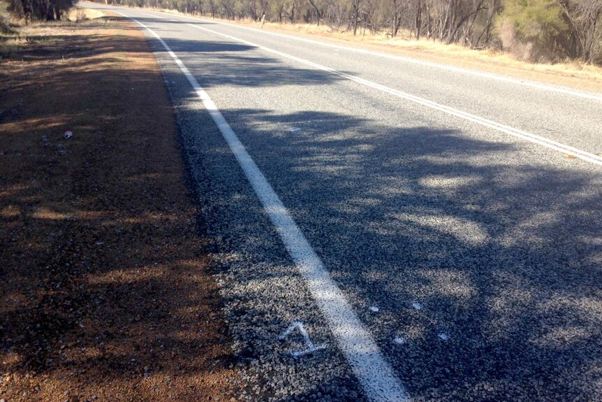 A stretch of regional highway with a number spray-painted on the bitumen.