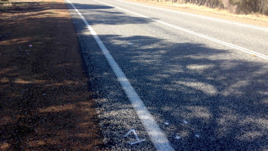 A stretch of regional highway with a number spray-painted on the bitumen.