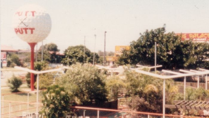 Aerial view of a putt putt course with a giant white golf ball elevated above the course.