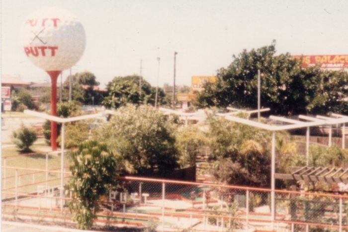 Aerial view of a putt putt course with a giant white golf ball elevated above the course.