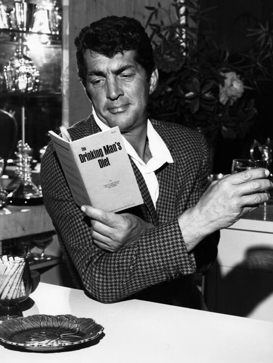 Dean Martin reads a copy of the Drinking Man's Diet
