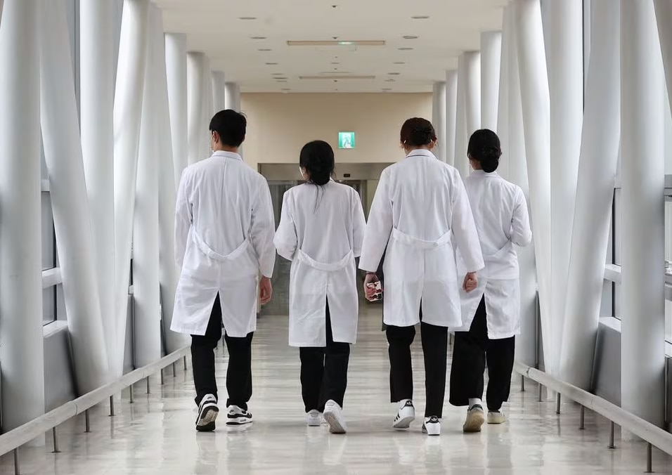 Medical workers in white coats walking inside a hospital 