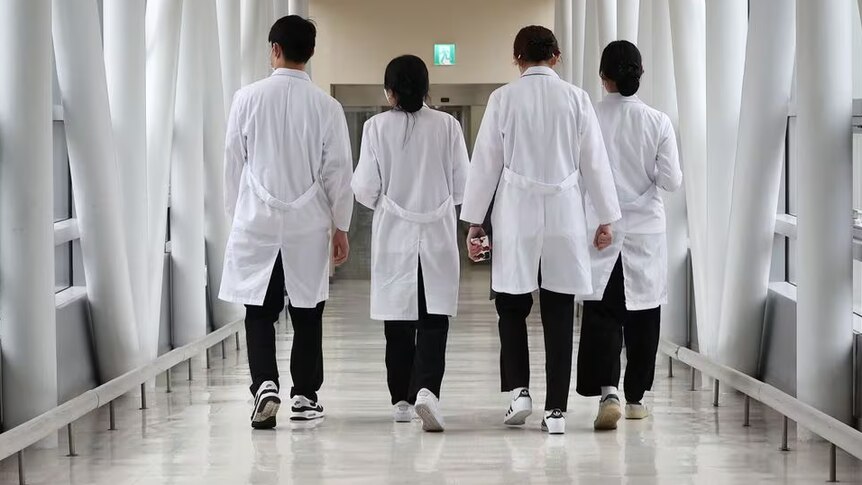 Medical workers in white coats walking inside a hospital 