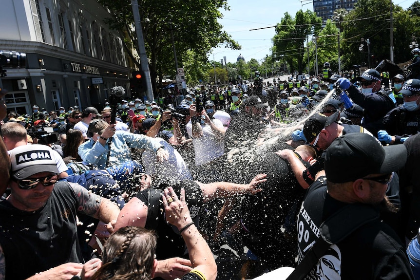 Police use capsicum spray on demonstrators at an anti-lockdown protest.