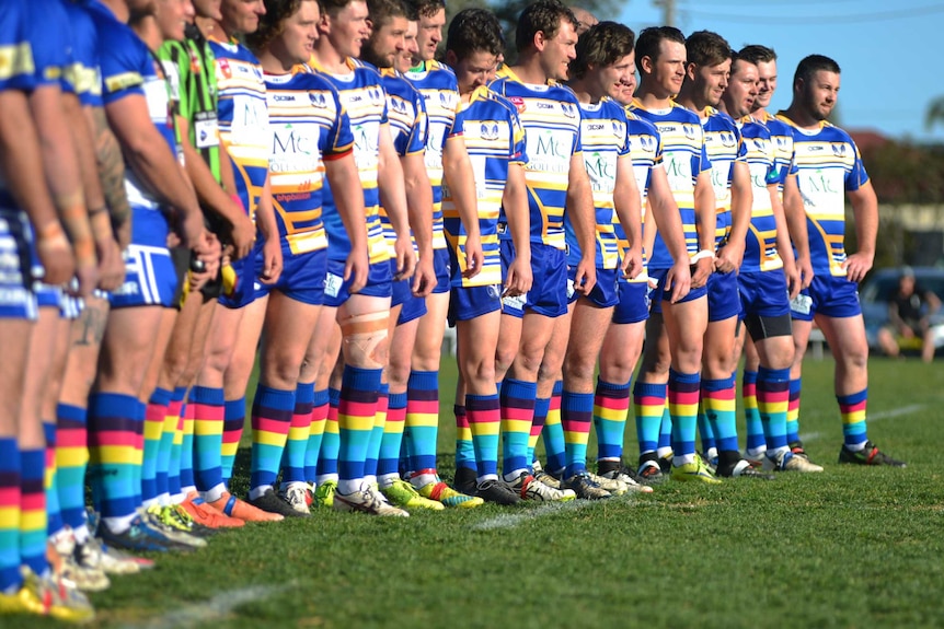 Rugby players stand in a row