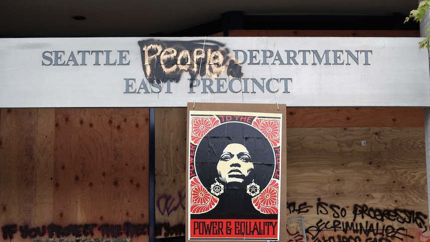 A 1970's-era poster of activist Angela Davis hangs at a boarded up and closed Seattle police precinct.