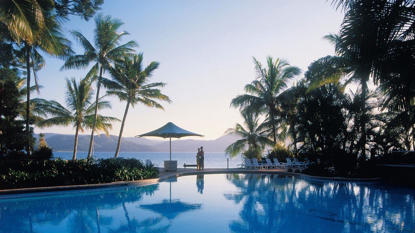 A couple overlooking a pool at Daydream Island's resort in the Whitsundays in north Queensland.