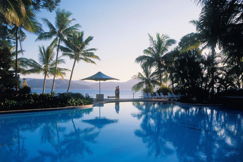 A couple overlooking a pool at Daydream Island's resort in the Whitsundays in north Queensland.