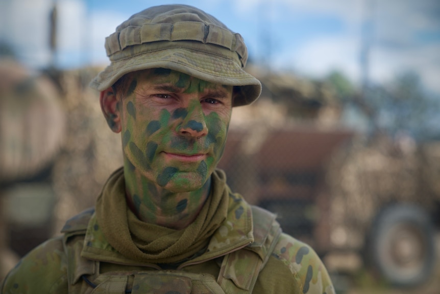A man with camoflage paint on his face.