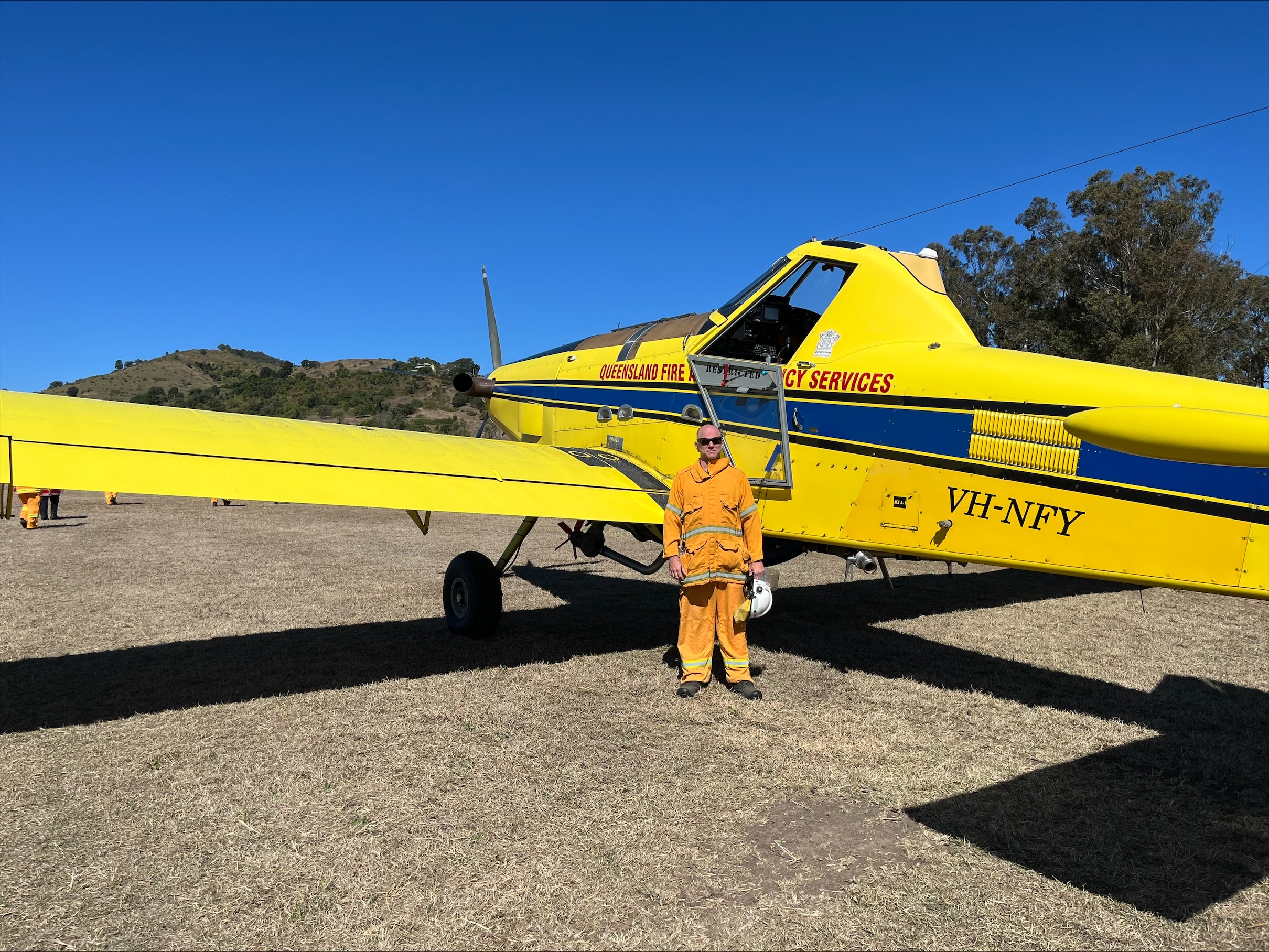 Rural Fire Service Queensland volunteer standing in front of plane.