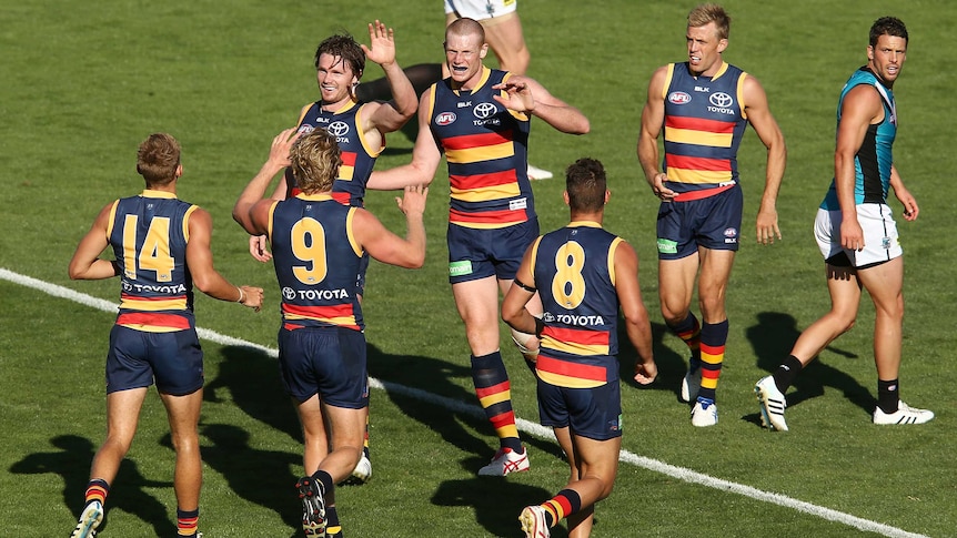 Crows players celebrate a goal against Port Adelaide in their preseason challenge match.