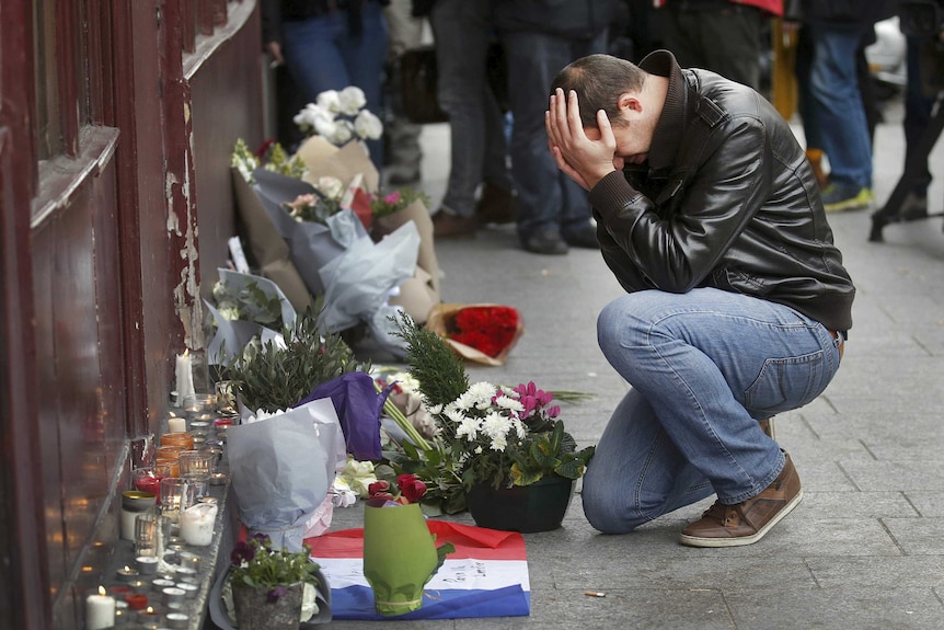 A man pays his respect outside the Le Carillon restaurant