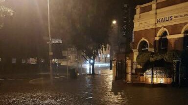 A street in Fremantle is badly flooded, with rain completely covering the ground.