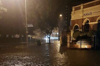 A street in Fremantle is badly flooded, with rain completely covering the ground.