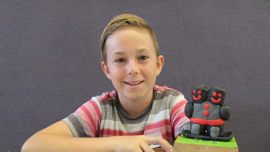 Young artist Java with two headed robot sculpture