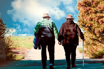 Older couple walking along a road hand-in-hand