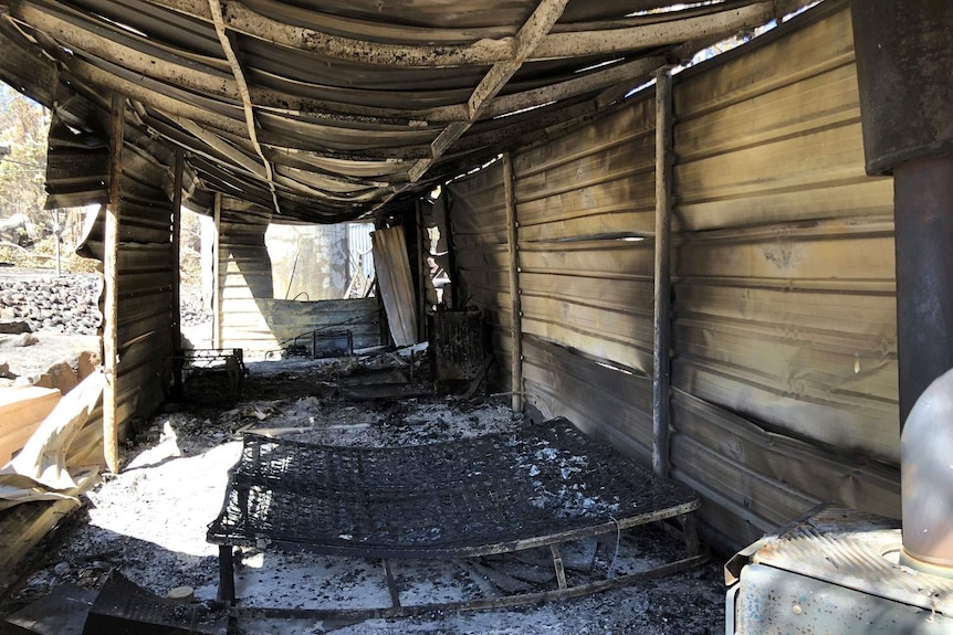 Bushfire-destroyed house with remnants of bed inside at Stanthorpe property.