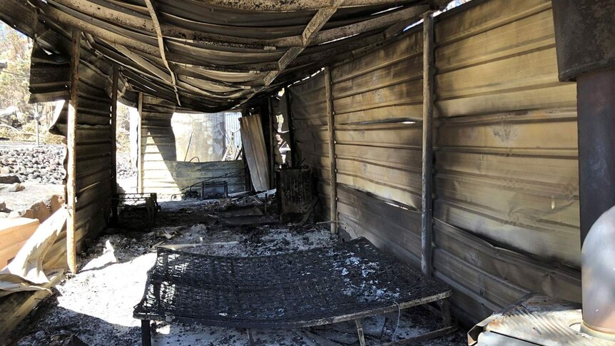 Bushfire-destroyed house with remnants of bed inside at Stanthorpe property.
