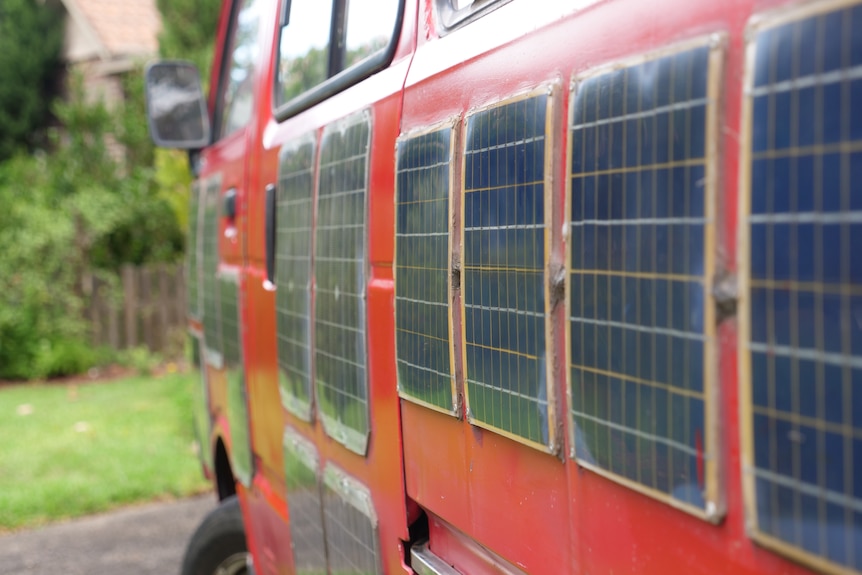 small solar panels fixed on to the side of a red van