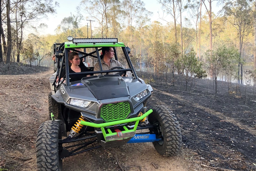 Residents on a quad bike survey a Narangba property where fire broke out.