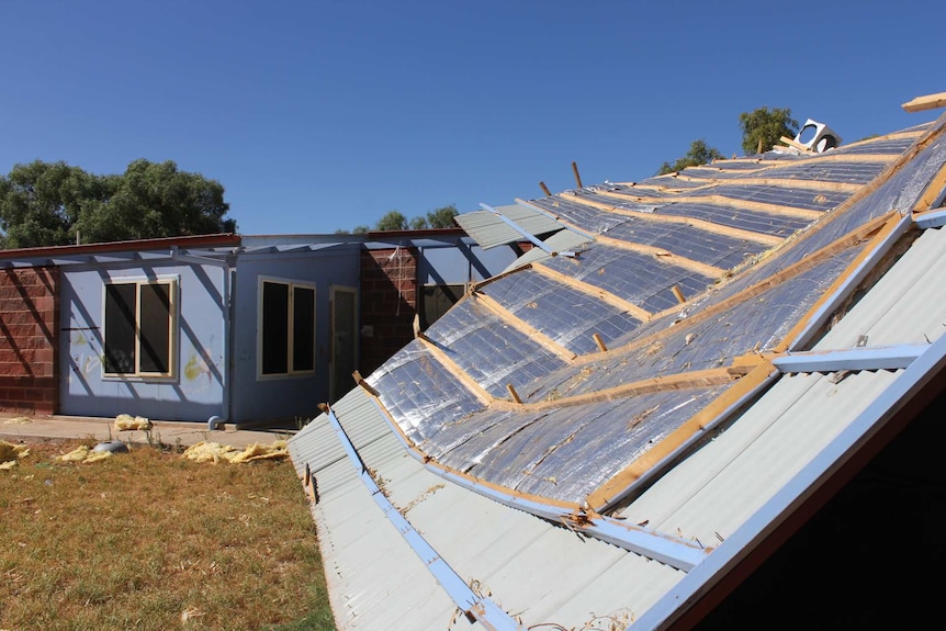 The roof of a single storey house half blown off