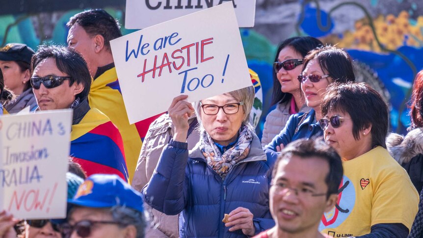 An anti-China protester holds a sign that reads 'We are Hastie too'