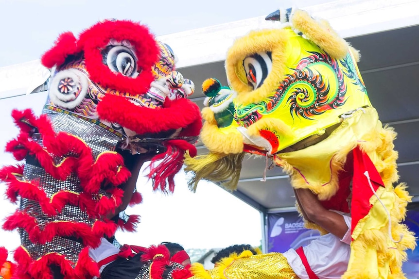 Two men in dragon costumes dancing