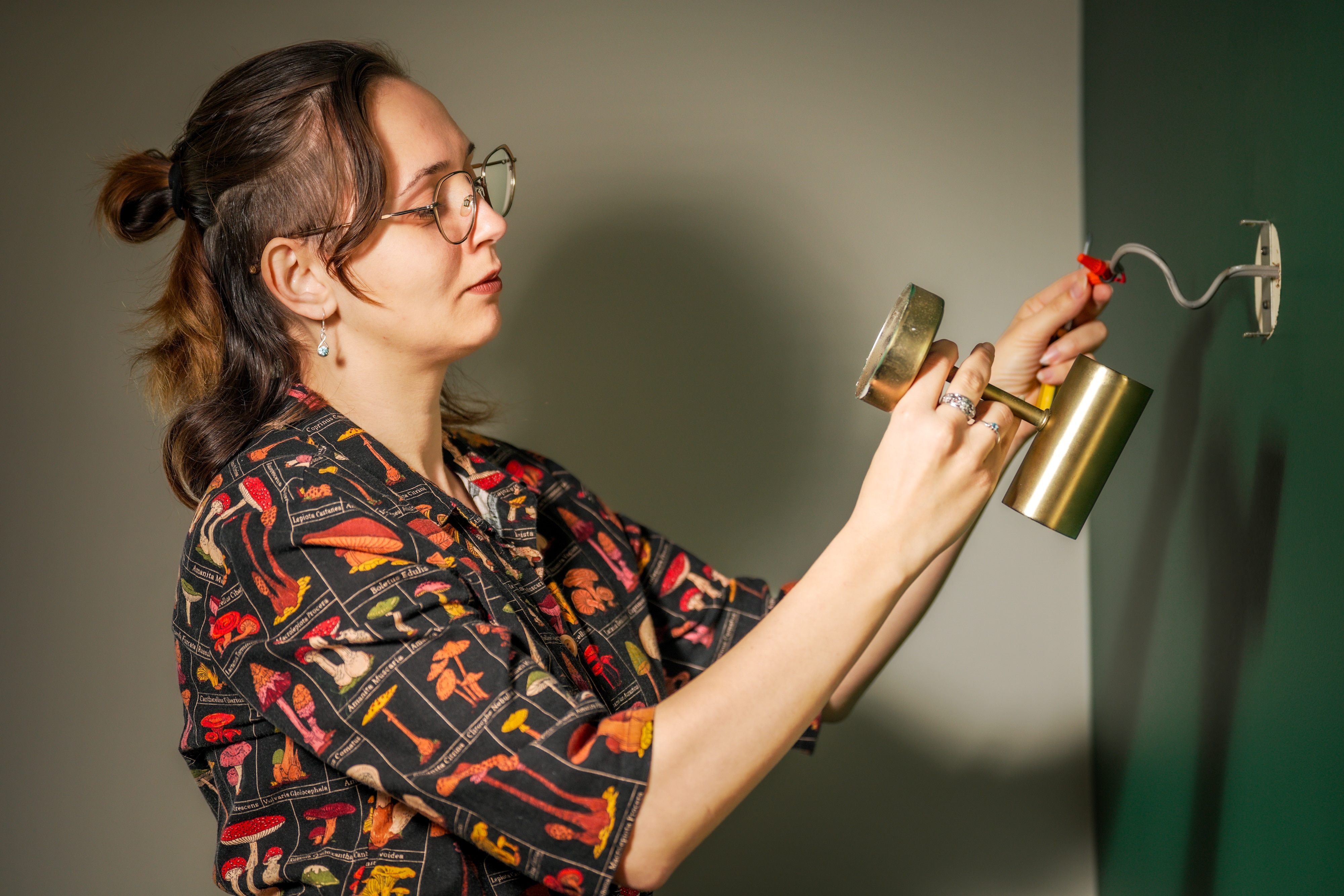 A woman at a light fitting. 