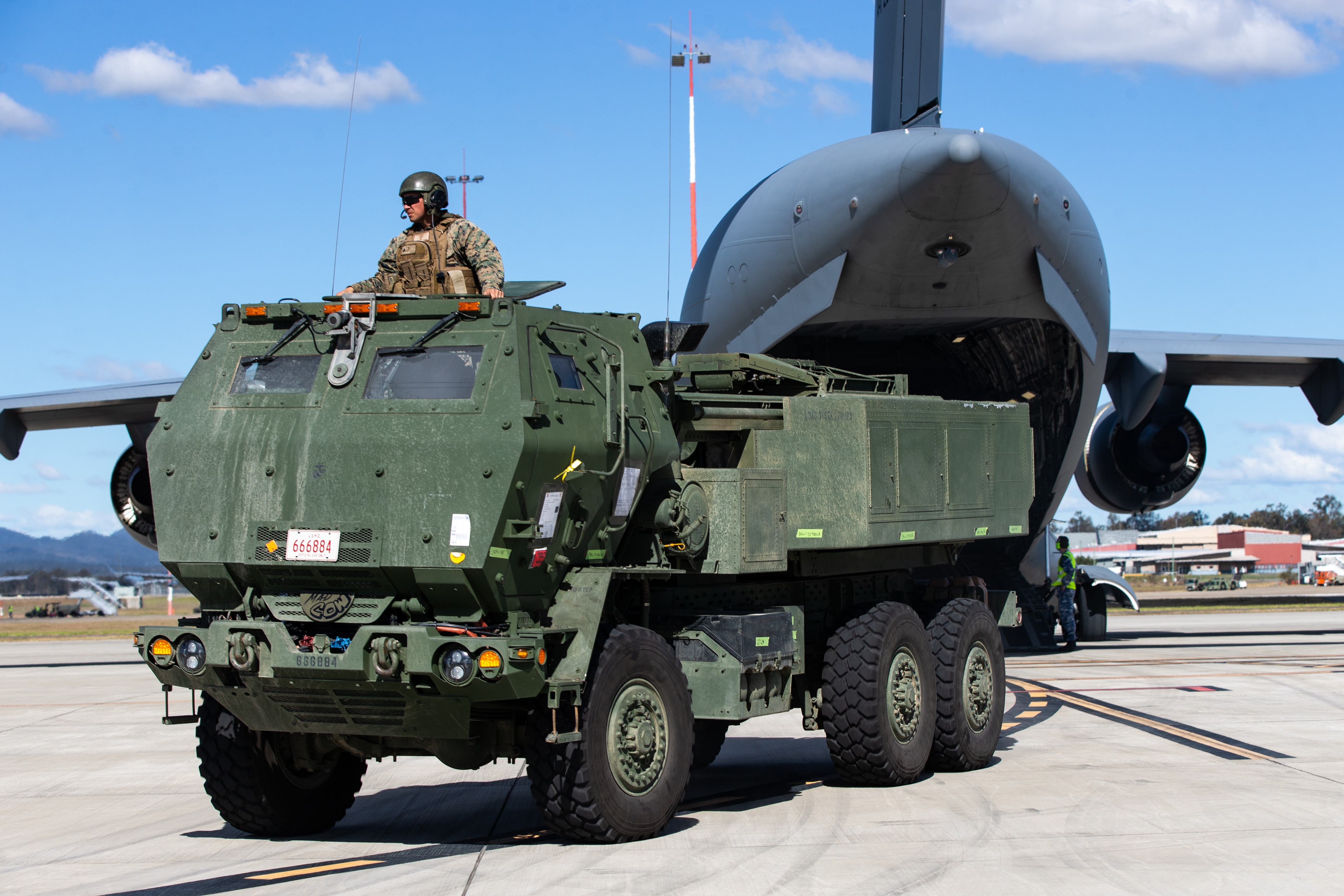 A HIMARS missile truck is offloaded from a RAAF C-17 cargo plane.