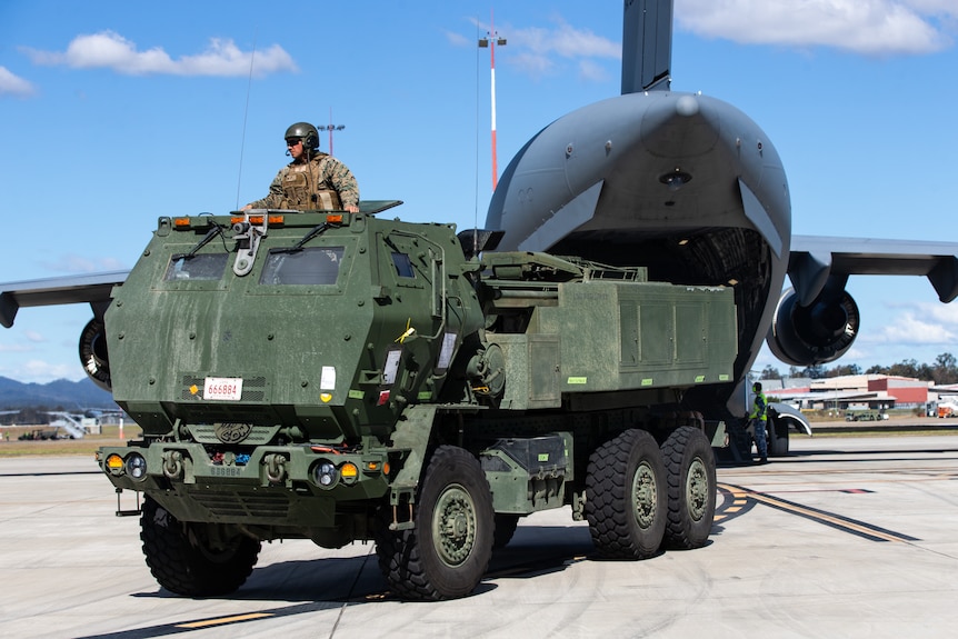 A HIMARS missile truck is offloaded from a RAAF C-17 cargo plane.