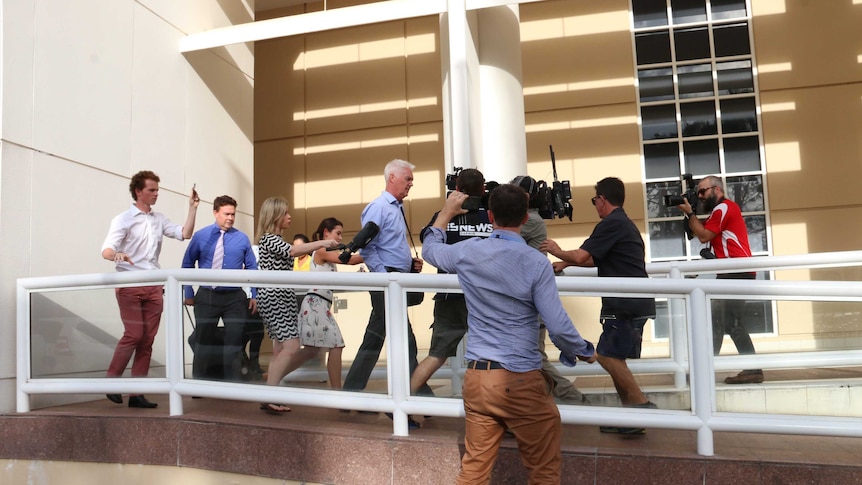John McRoberts is trailed by the media as he leaves the court house