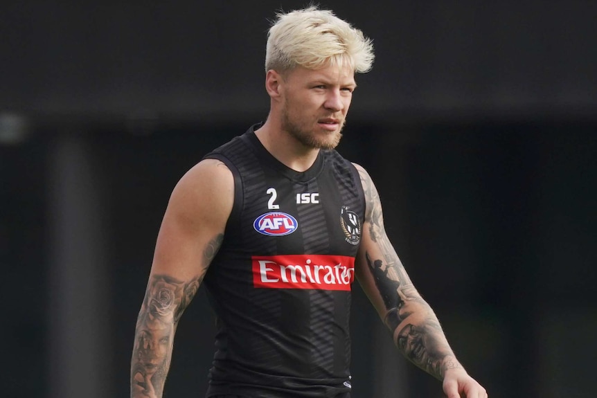 A Collingwood Magpies AFL player walks during a break at a training session in Melbourne.