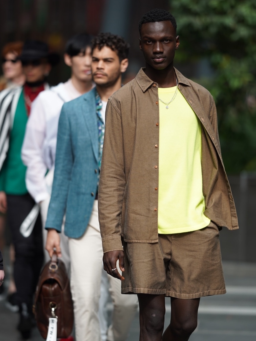 A man walks down a runway in a short suit