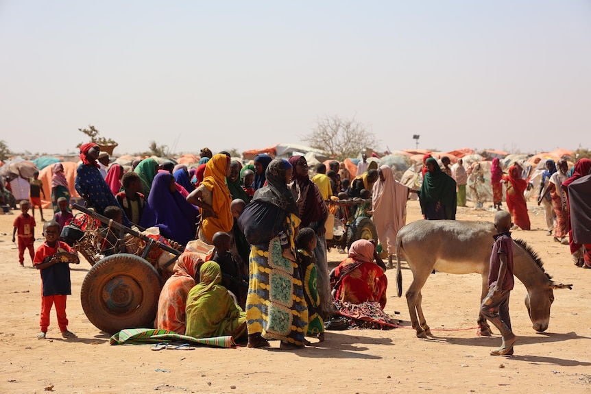 Women and children standing.