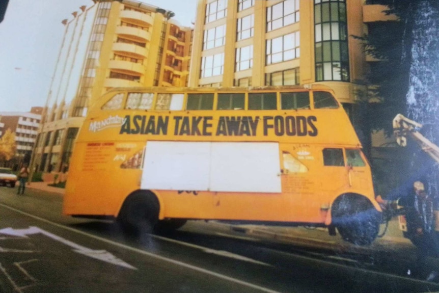 An old photo shows a yellow bus in Braddon, Canberra, that reads 'Asian Take Away Foods'.
