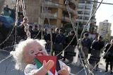 Lebanese and Palestinian protestors hang a doll symbolising a wounded Palestinian child